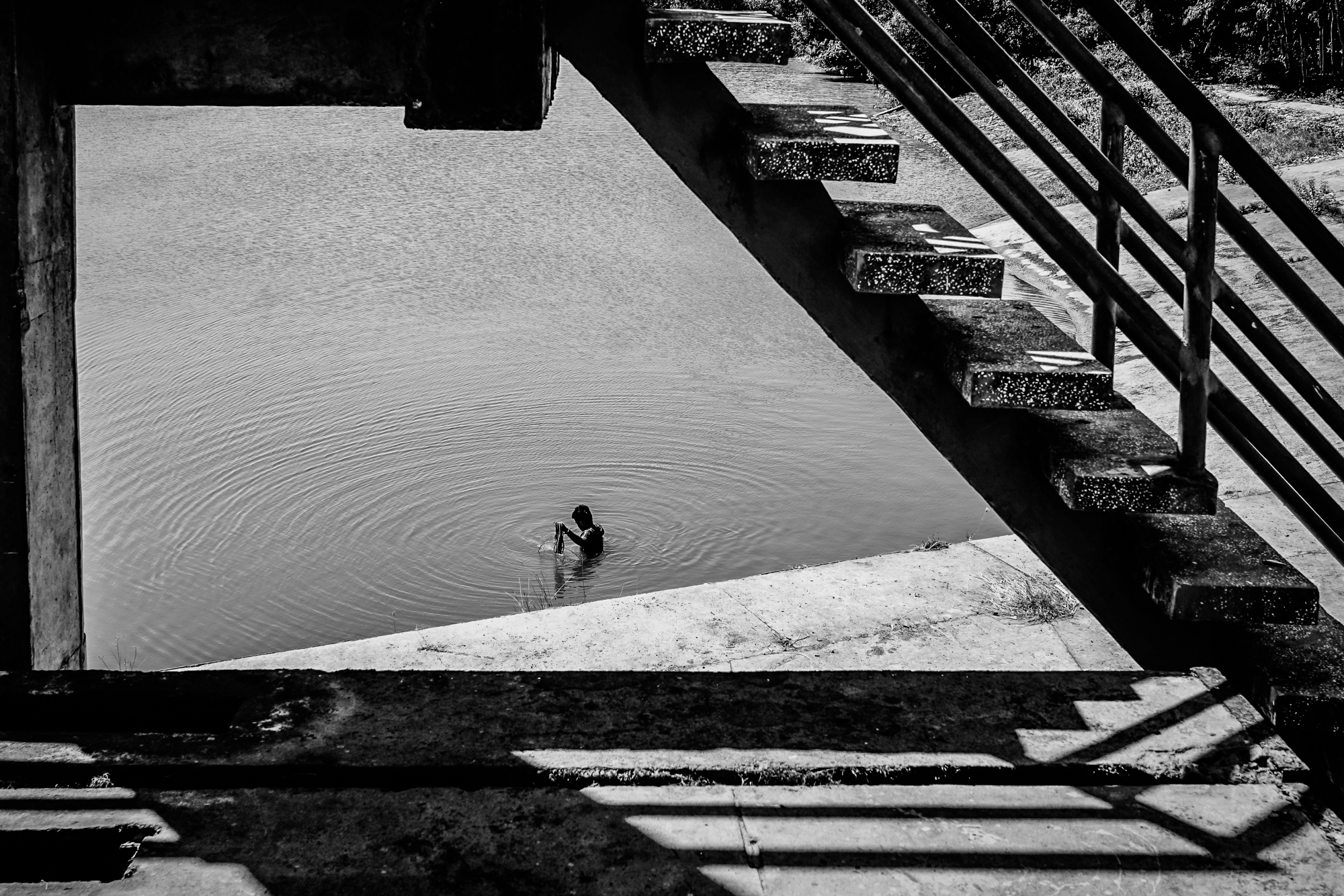 A man fishes in a water lock meant to keep salt water from intruding on rice fields in Mekong Delta, Vietnam