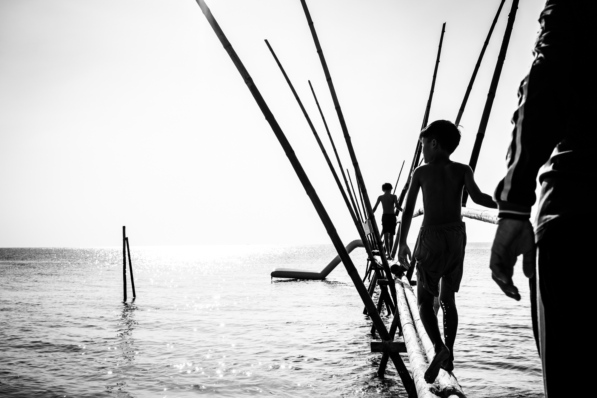 Boys play on a bamboo pier on the island’s well know Long Beach stretch.