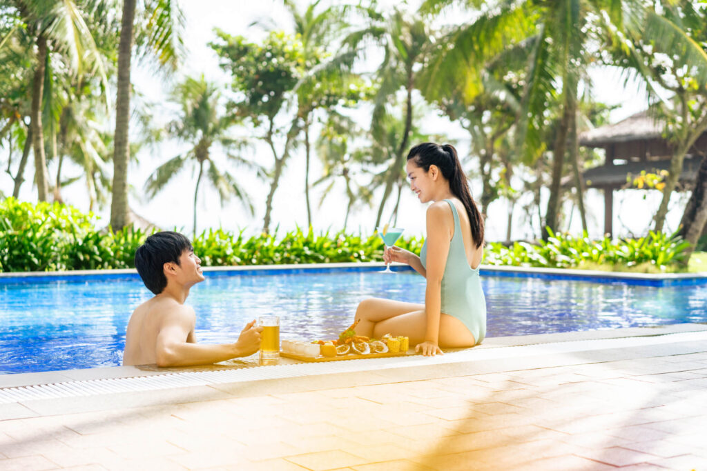 A couple enjoys time together in the pool at a luxury beachfront resort in Danang, Vietnam.