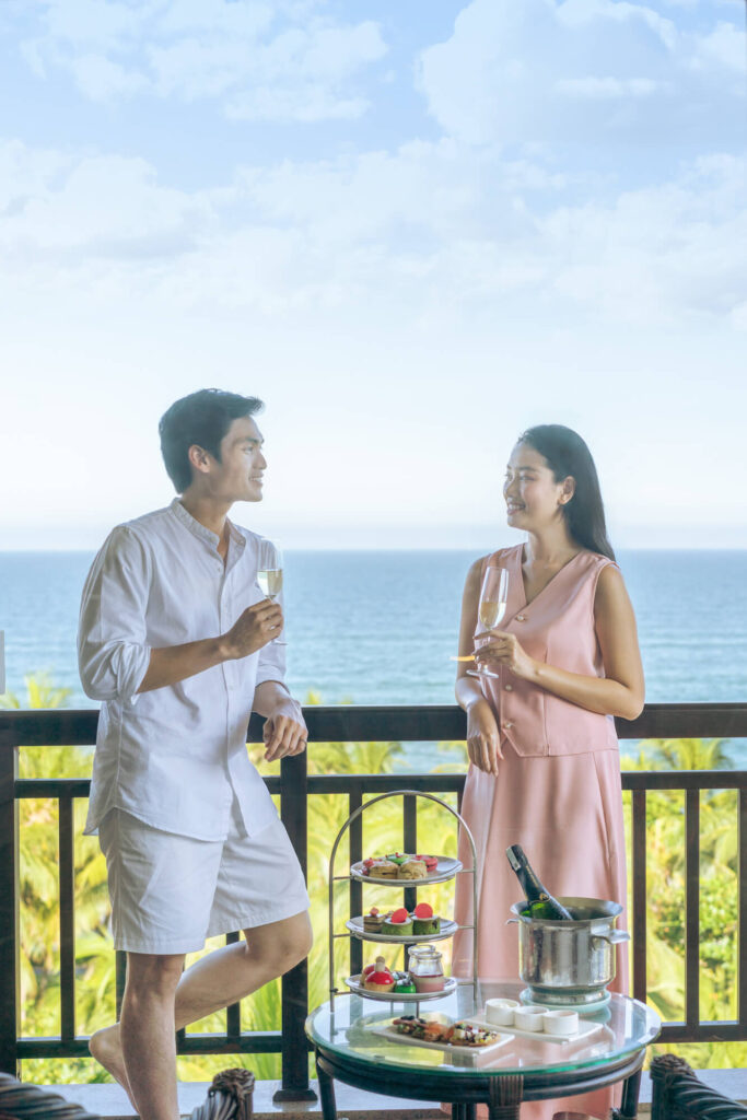 A couple enjoys afternoon tea on their beachfront balcony at a luxury resort in Danang, Vietnam.