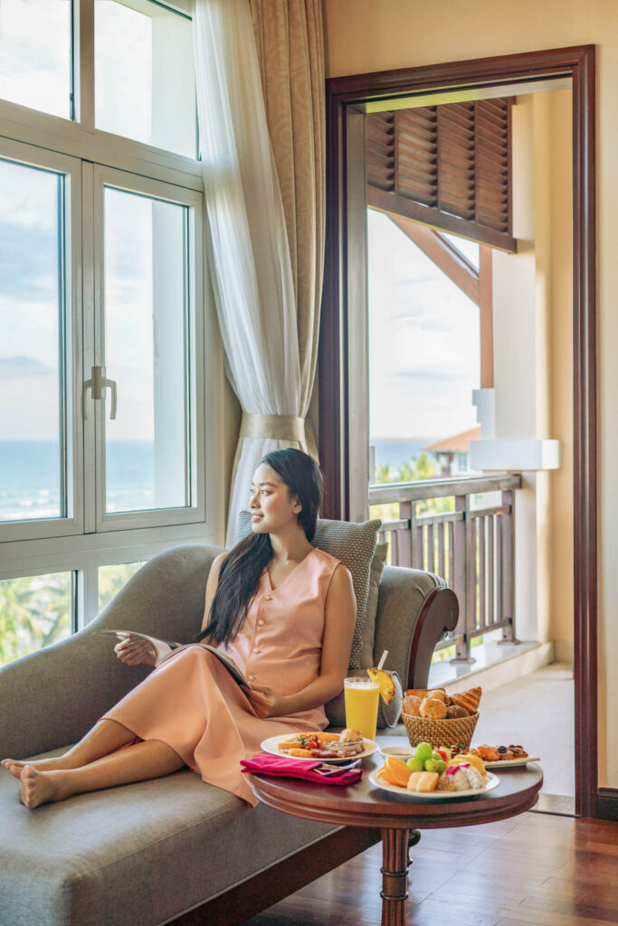 A woman enjoys breakfast in room at a luxury resort in Vietnam.