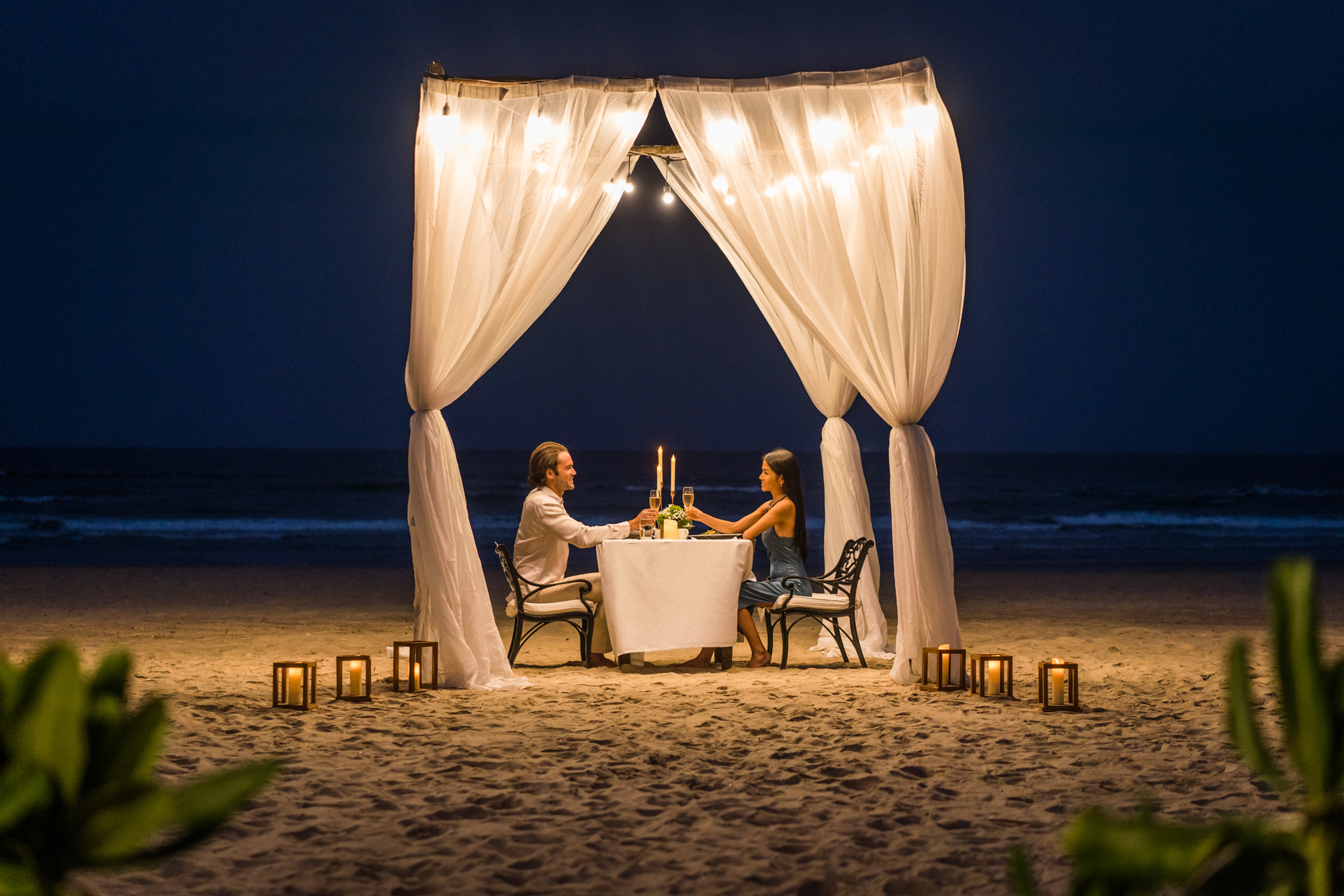A couple has a private beach dinner at a five star resort in Vietnam