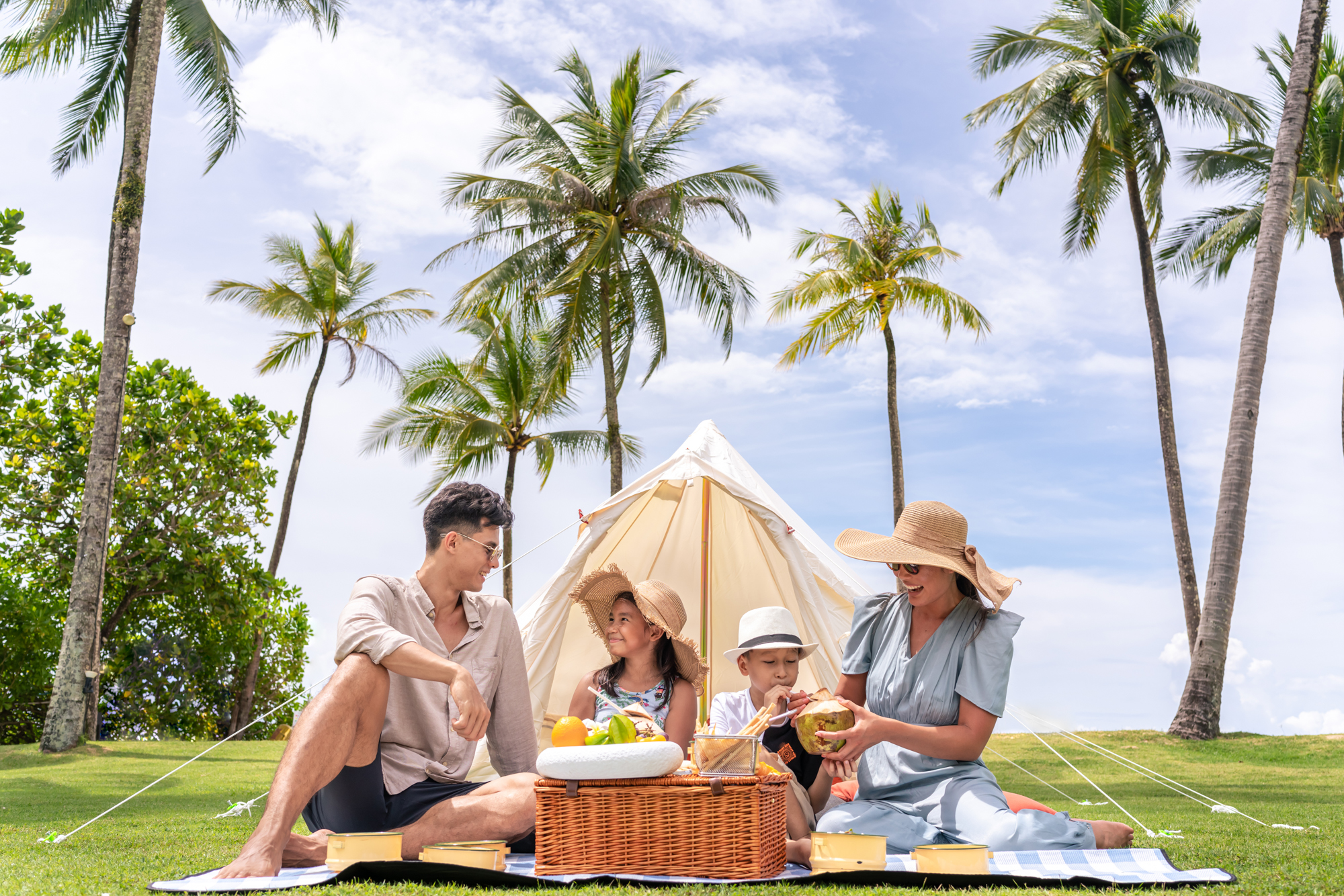 A family enjoys a picnic by the beach at a luxury resort in Thailand