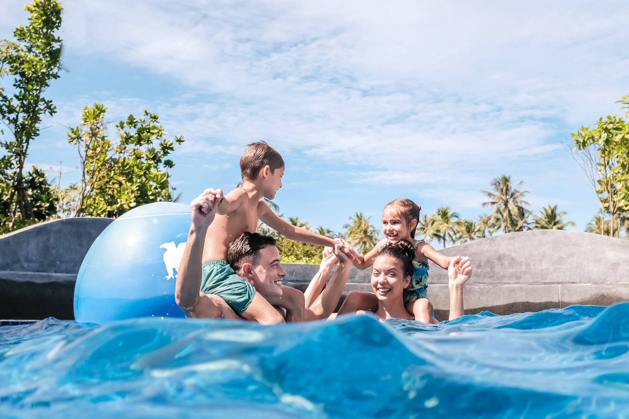 A family plays in the wave pool at a 5 star resort in Thailand