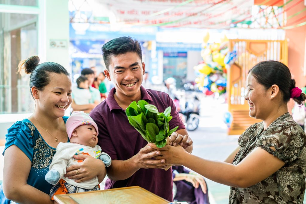 A family receives a package of organic vegetables at a nutrition clinic in Ho Chi Minh City, Vietnam