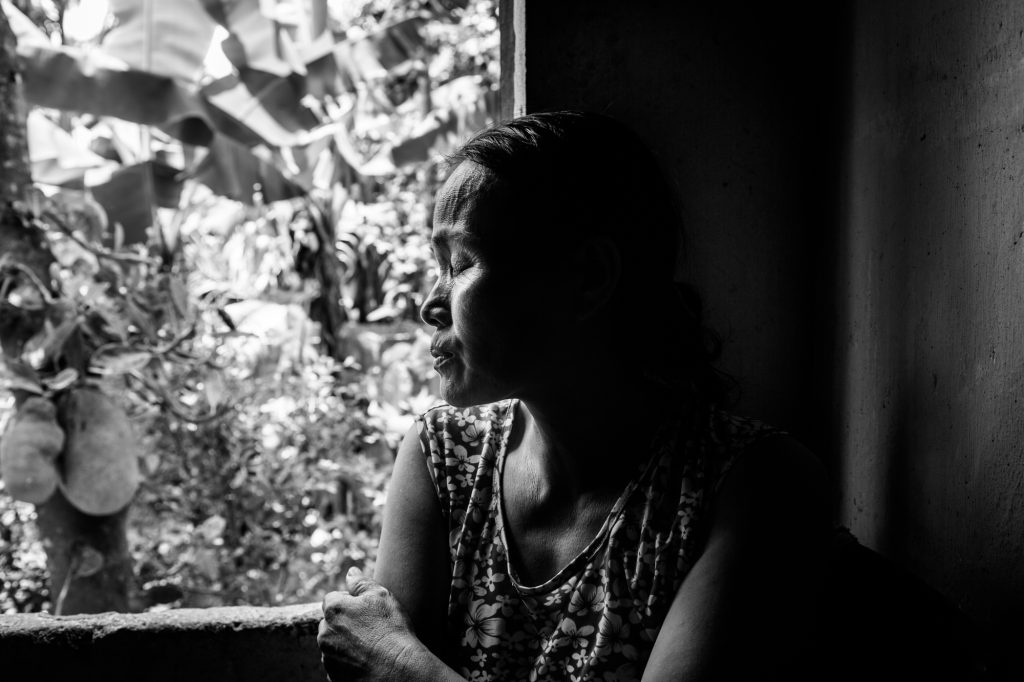 A woman with two sons affected by Agent Orange has a moment of quiet reflection in her home in Danang, Vietnam