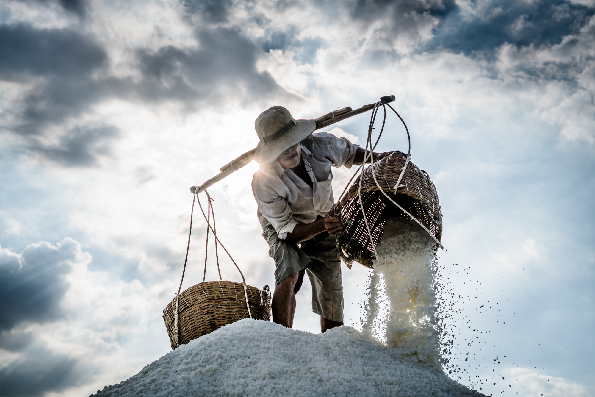 A man works to harvest salt in the late afternoon sun in Can Gio, Vietnam, outside of Ho Chi Minh City.