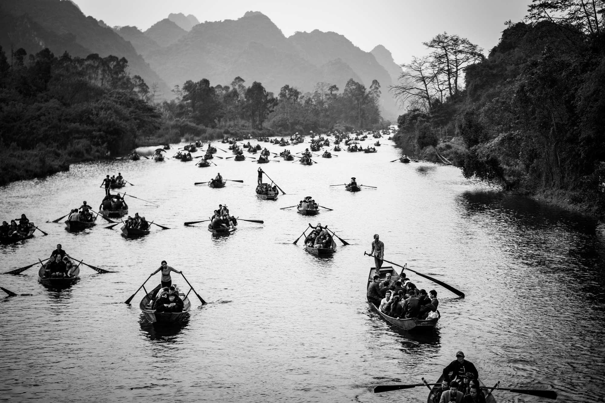 Boats of tourists making a pilgrimage trip to a pagoda on the Perfume River in northern Vietnam.