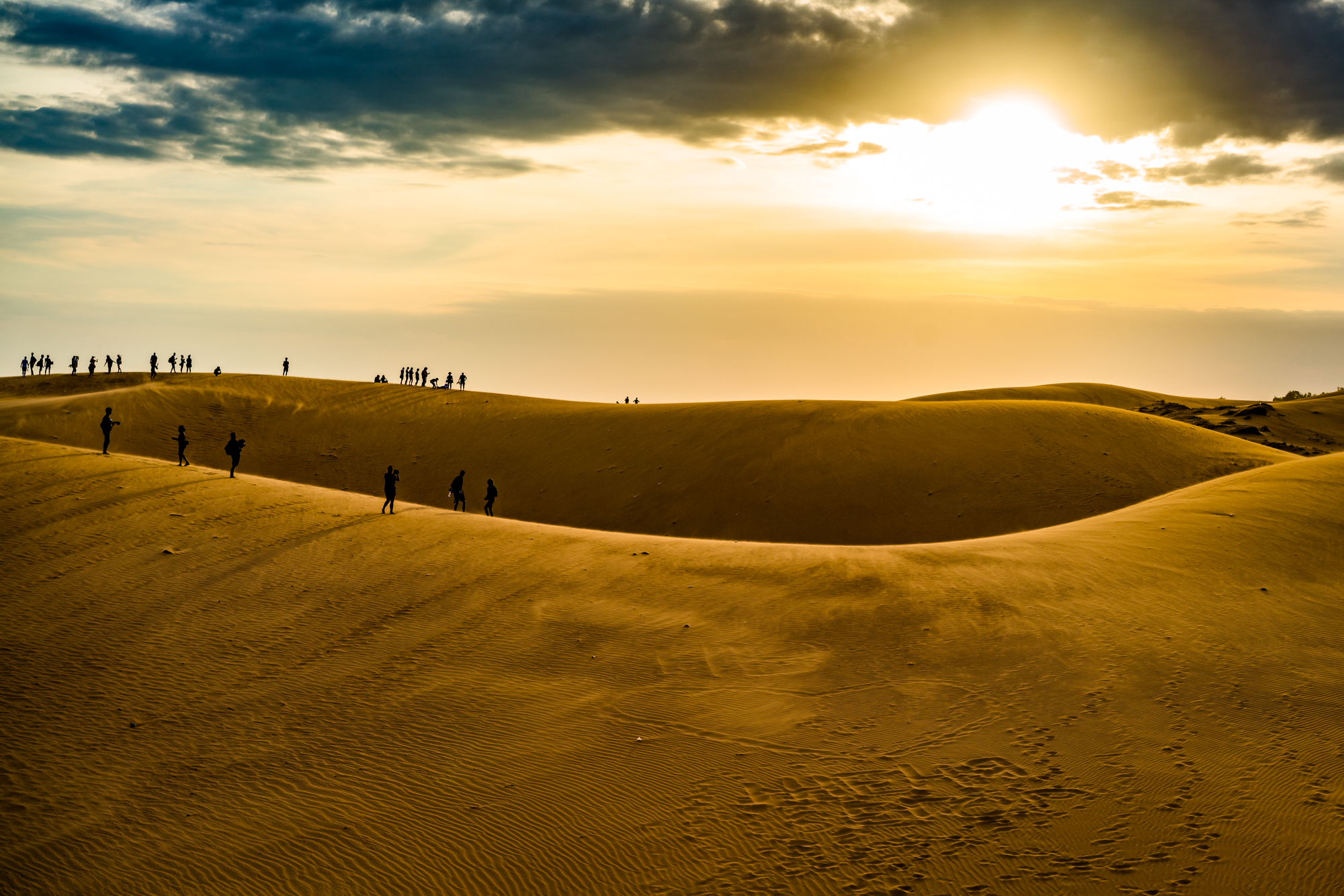 Visitors atop the red sand dunes in Mui Ne, Vietnam
