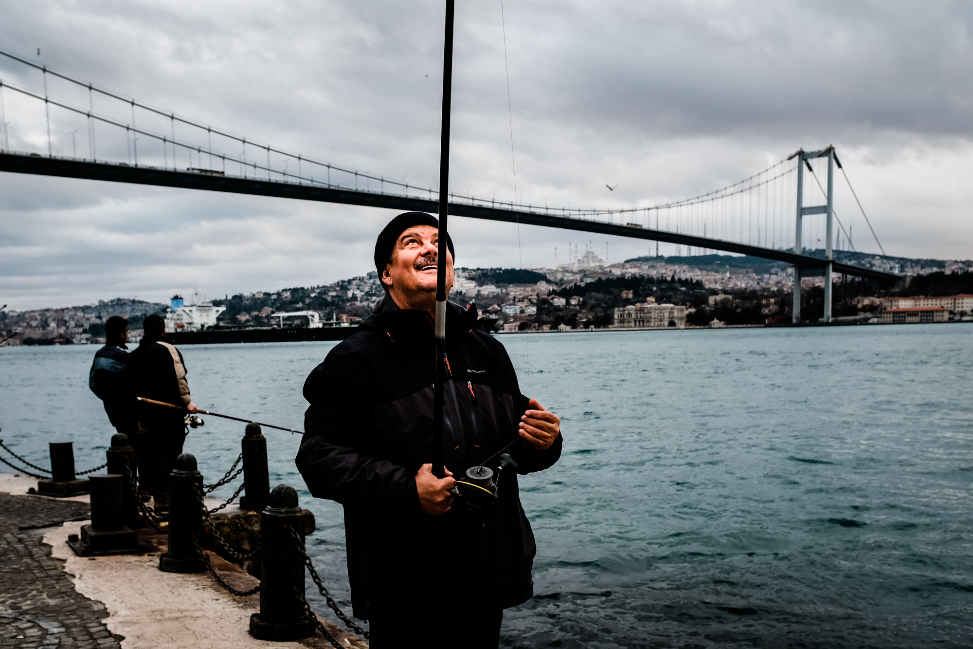 A fisherman on the banks of the Bosporus River in Istanbul, Turkey
