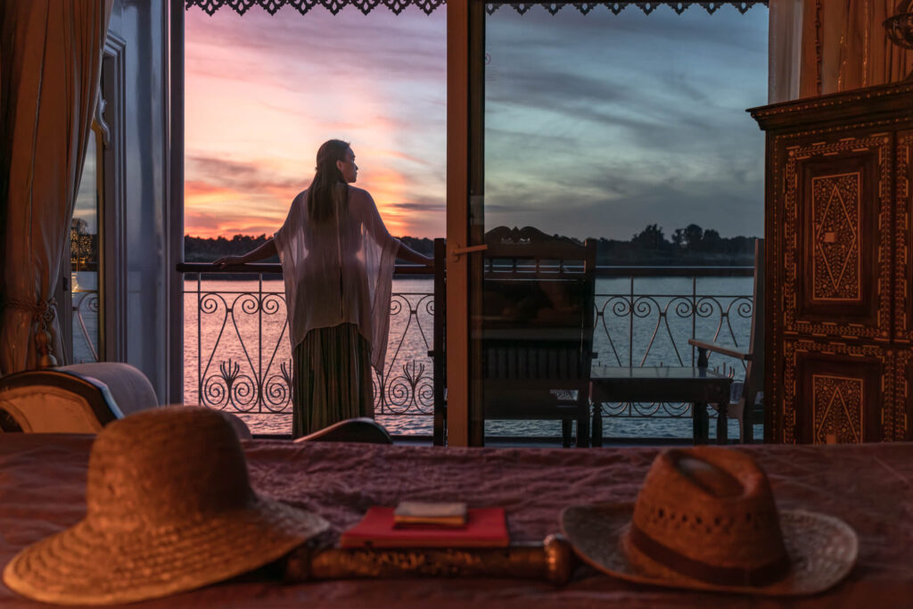 A guest takes in the beautiful sunrise from the balcony of a luxury river cruise ship on a route between Vietnam and Cambodia. Captured by Vietnam hospitality and cruise photographer Quinn Ryan Mattingly.