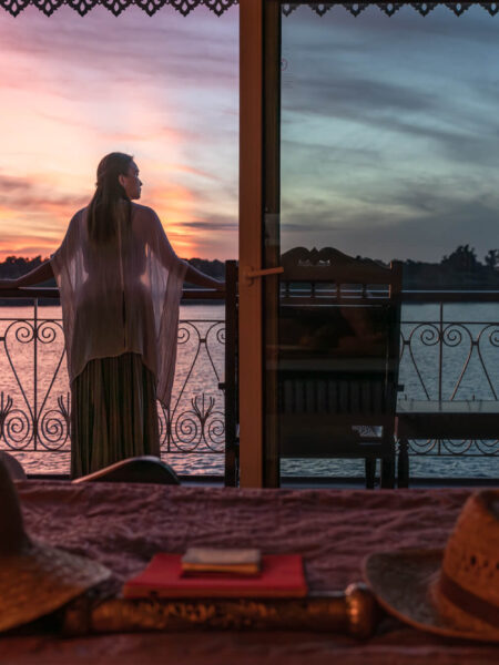 A guest takes in the beautiful sunrise from the balcony of a luxury river cruise ship on a route between Vietnam and Cambodia. Captured by Vietnam hospitality and cruise photographer Quinn Ryan Mattingly.